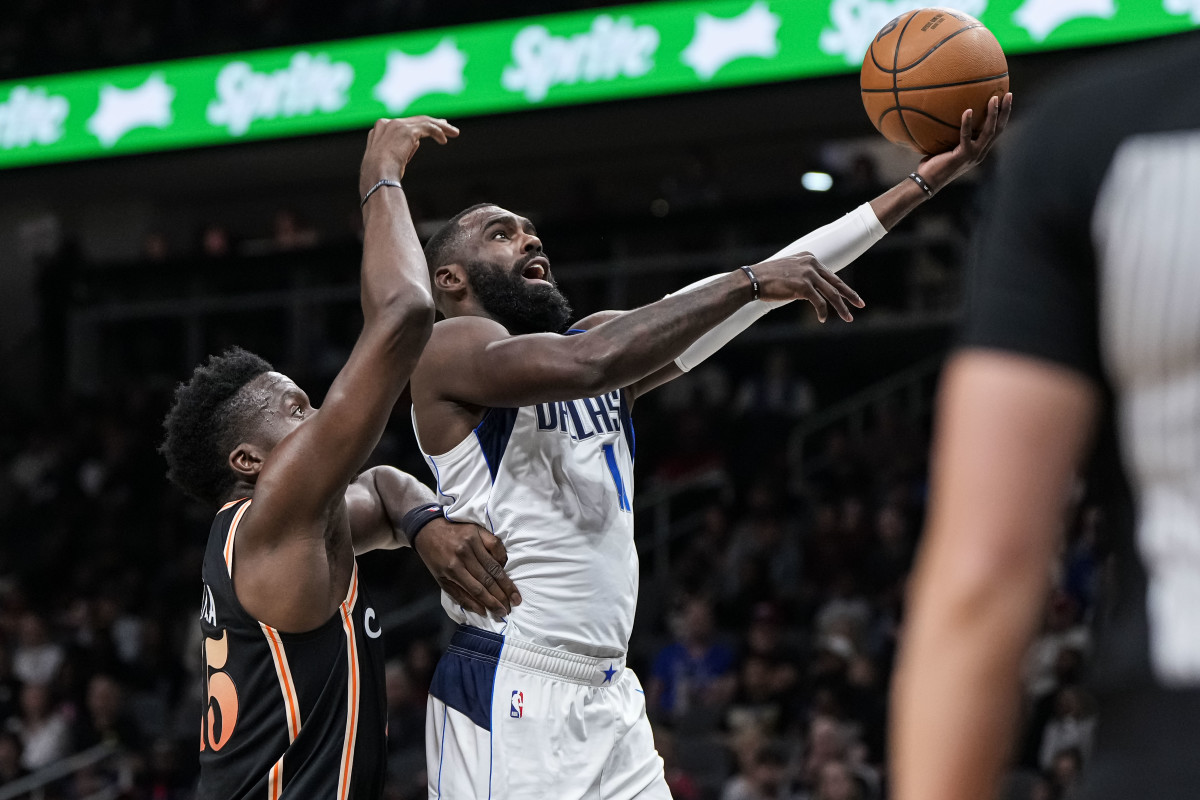 Mavericks guard Tim Hardaway Jr. drives past Hawks center Clint Capela for a left-handed layup.